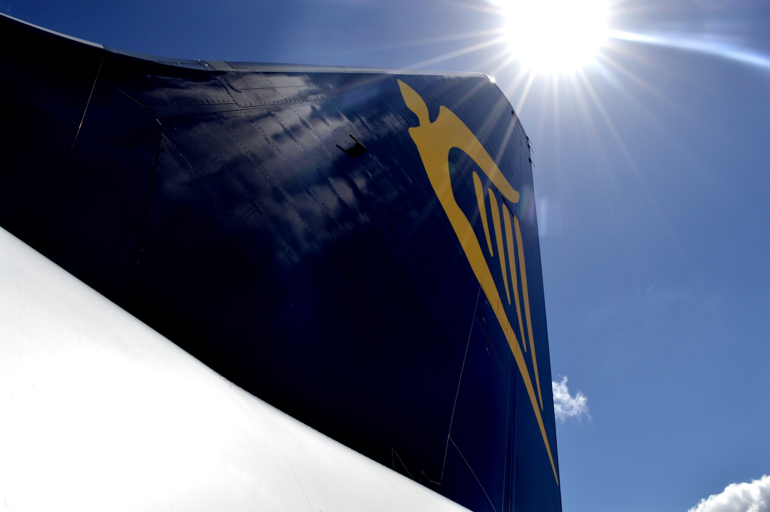 picture of Ryanair tail fin with the sky and sun in the background