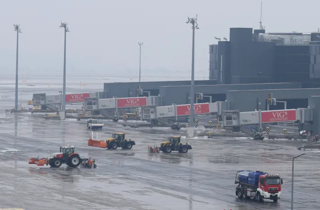Snowplows clear ice and snow from the tarmac at Vienna International Airport in Schwechat, Austria