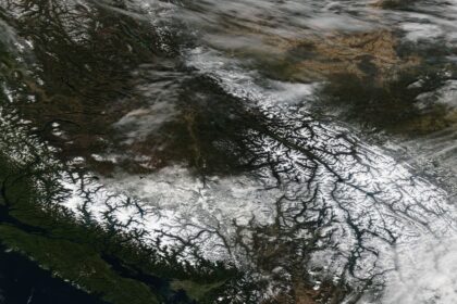 Satellite image of snow-covered regions in British Columbia and Alberta illustrating severe winter weather, linked to Canada flight disruptions, flight delays Canada, and flight cancellations Canada.