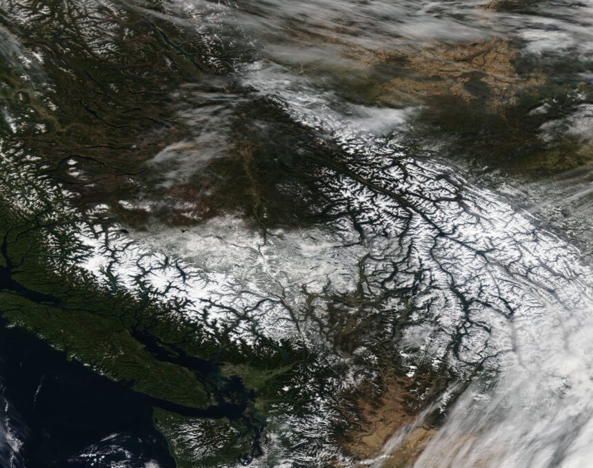Satellite image of snow-covered regions in British Columbia and Alberta illustrating severe winter weather, linked to Canada flight disruptions, flight delays Canada, and flight cancellations Canada.