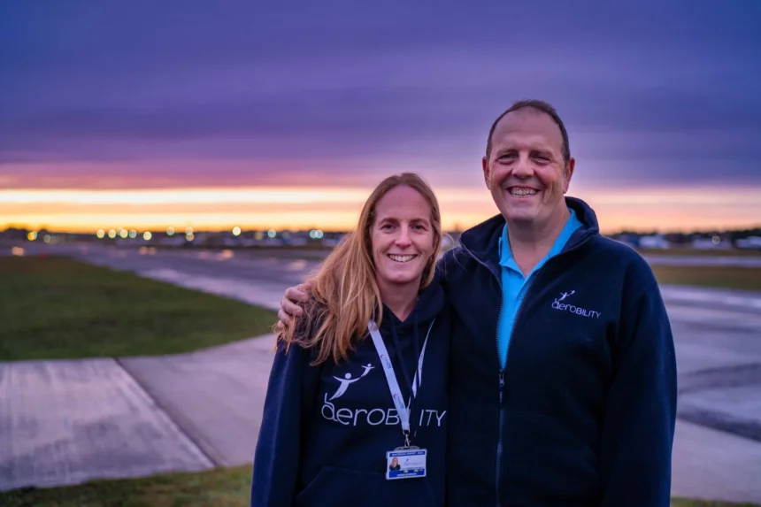 Shona Bowman (Former Aerobility Chairman) hugs Neil Tucker, newly appointed Aerobility Chair at Blackbushe Airport, at sunset.