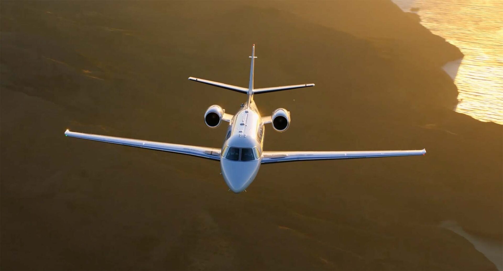Citation Ascend business jet flying close to a shoreline.