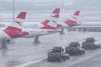 Planes parked on icy runways at Vienna International Airport, operations halted as thick ice repeatedly refreezes despite clearing efforts.