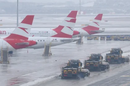 Planes parked on icy runways at Vienna International Airport, operations halted as thick ice repeatedly refreezes despite clearing efforts.