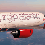 Virgin Atlantic aircraft flying, sunset background.