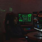 A hacker sat in front of screens