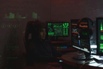A hacker sat in front of screens