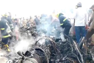 Onlookers view the smoke rising from the debris