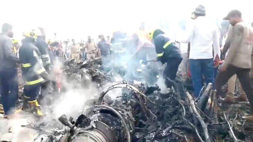 Onlookers view the smoke rising from the debris