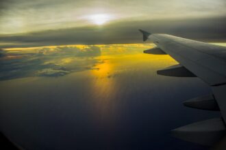 Aircraft wing over the ocean at sunset illustrating China sustainable aviation fuel, Topsoe SAF, SAF production China, China SAF production capacity expansion, and sustainable aviation fuel projects in China.