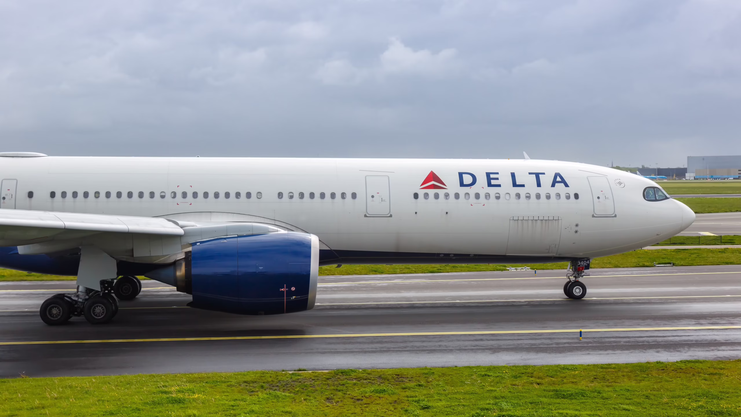 Side view of a Delta Air Lines Airbus A330neo on the runway, showing its twin engines
