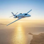 Citation Ascend business jet flying close to a shoreline.