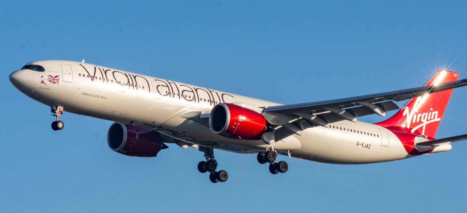 Virgin Atlantic aircraft flying in the blue sky.