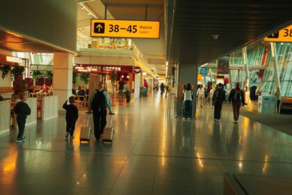 Lotnisko Chopina Warszawa (WAW) airport inside, with a few people walking.