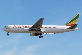 Ethiopian Airlines Boeing B767-300ER flying in blue sky, with the landing gear down.