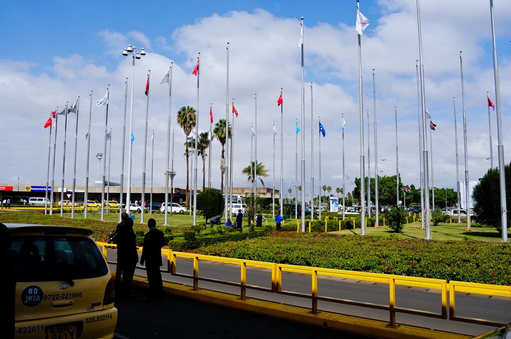 Jomo Kenyatta International Airport with several flags and a blue sky.