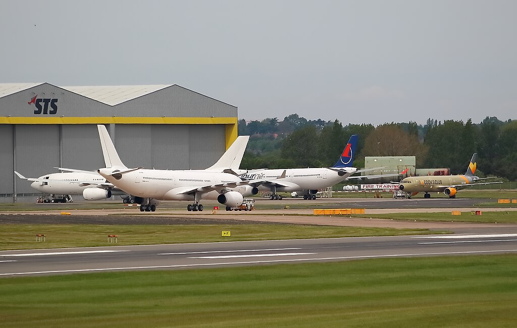 four aircraft grounded, STS logo on building, grey skies