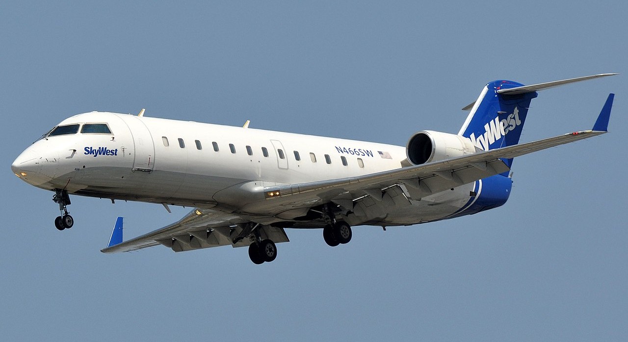 SkyWest aircraft flying in the blue sky.