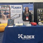Kadex employee stood behind Kadex company stall at an annual conference.