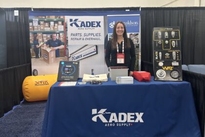 Kadex employee stood behind Kadex company stall at an annual conference.