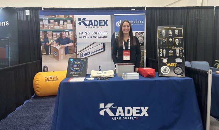 Kadex employee stood behind Kadex company stall at an annual conference.