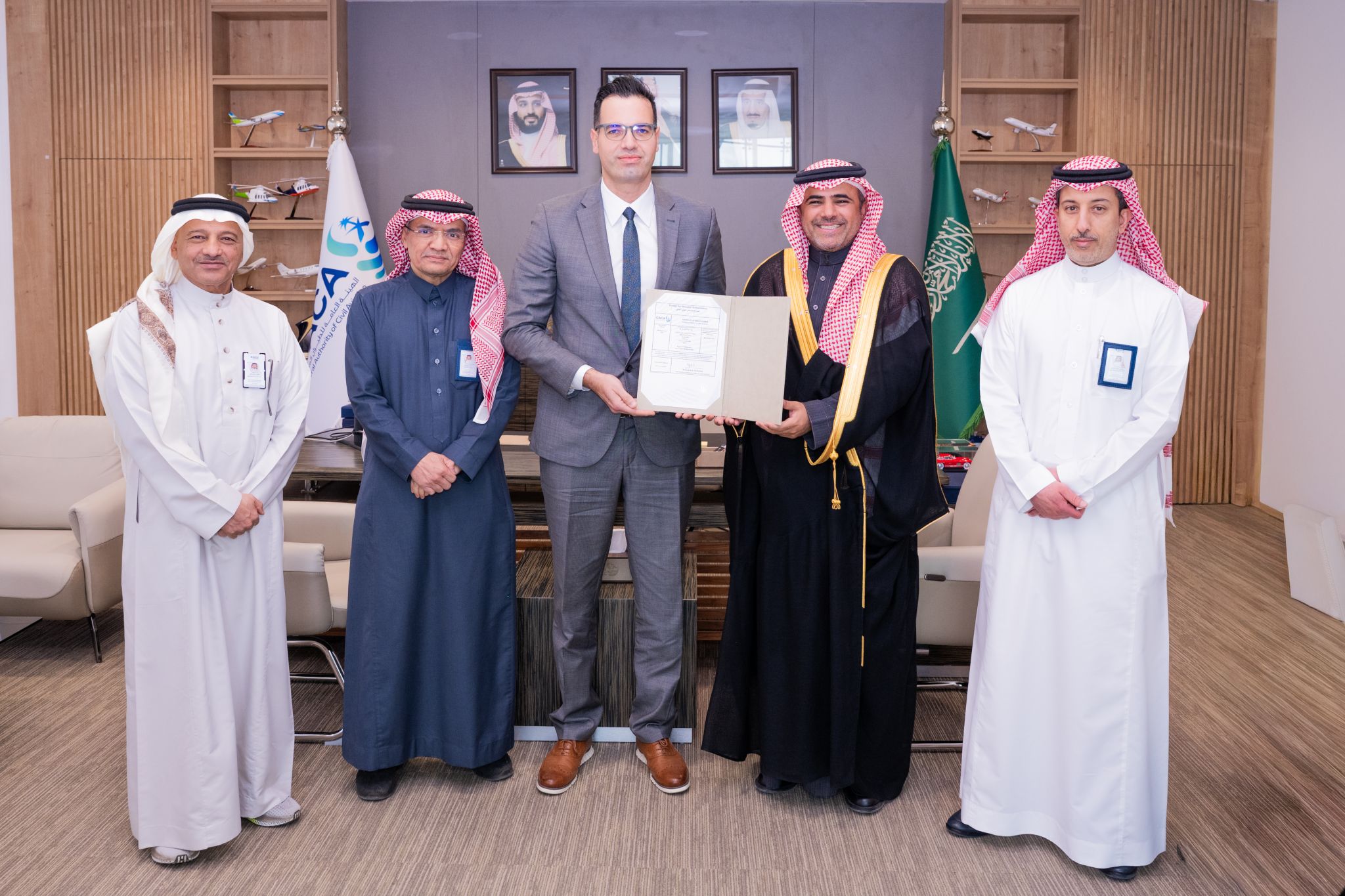 Group photo of five, CEO Houssam Hazzoury, holding a document.