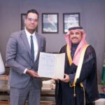 CEO of AirX, Houssam Hazzoury, shaking hands with someone, holding a document.