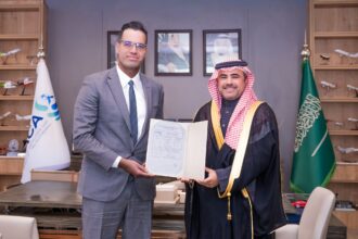 CEO of AirX, Houssam Hazzoury, shaking hands with someone, holding a document.