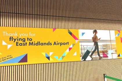 Arrival hall at the East Midlands Airport; welcoming poster on the wooden panel wall.
