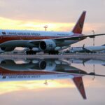TAAG aircraft on the tarmac, sunset in the background.