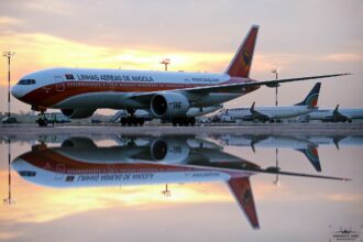 TAAG aircraft on the tarmac, sunset in the background.