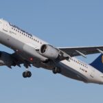Lufthansa Airbus A320-211 flying in the blue sky. Blue, yellow and white livery.
