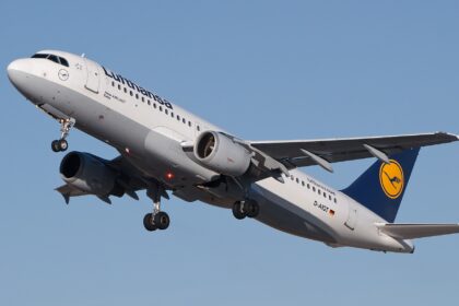 Lufthansa Airbus A320-211 flying in the blue sky. Blue, yellow and white livery.