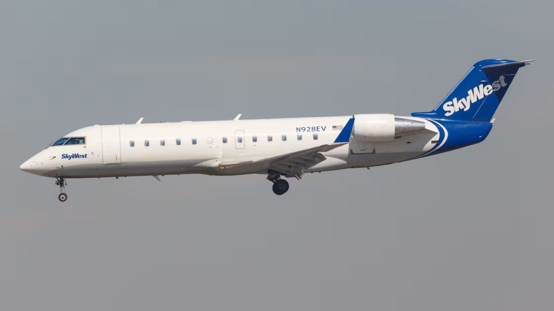 SkyWest aircraft flying, grey sky.