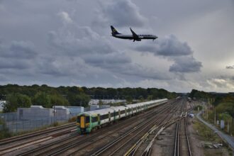 As a Ryanair Boeing 737-800 passes over on final approach, 377424 departs Gatwick Airport at the rear of 1J78 14:36 Victoria - Horsham & Bognor Regis.