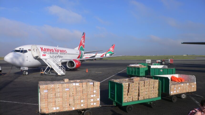 A Boeing 737 of Kenya Airways at the tarmac of the Jomo Kenyatta International Airport. Some parcels in the foreground.