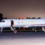 FlyHouse Gulfstream V aircraft on the tarmac in the dark.