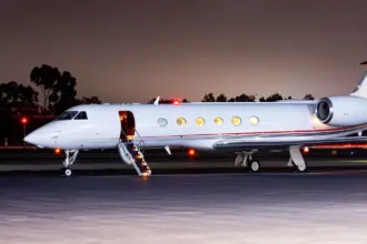 FlyHouse Gulfstream V aircraft on the tarmac in the dark.