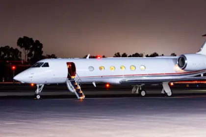 FlyHouse Gulfstream V aircraft on the tarmac in the dark.