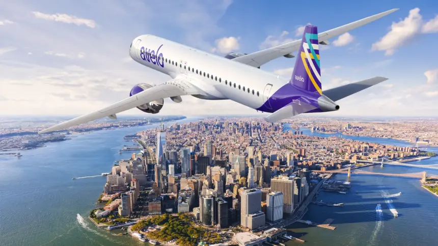 Avelo Airlines aircraft, flying over a city, blue sky.