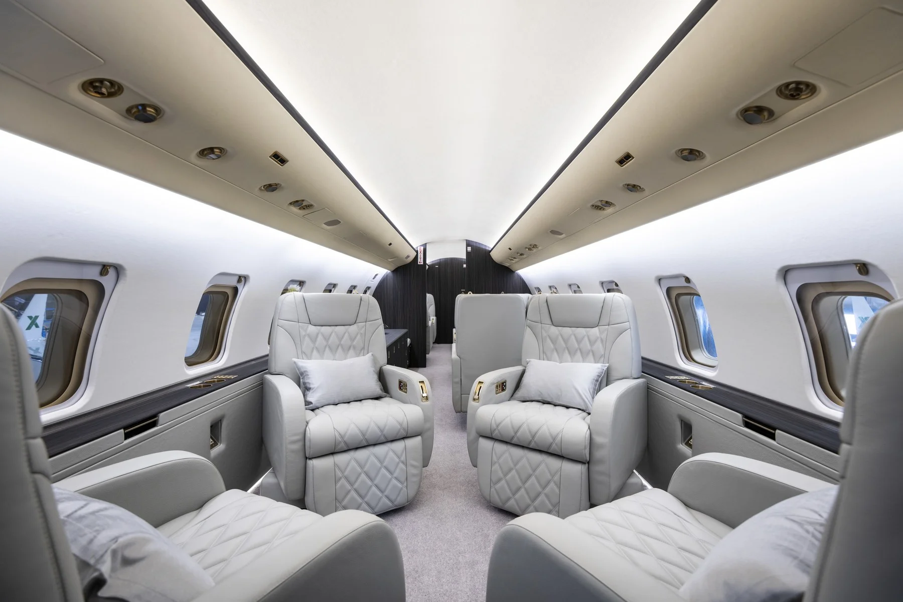 Interior of AirX private jet, luxury white chairs.