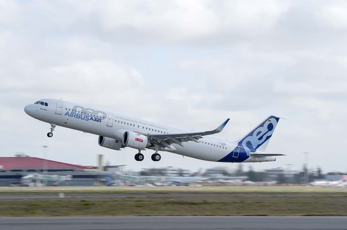 An Airbus A321neo passenger aircraft in flight against a blue sky.