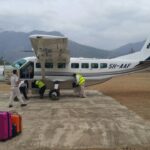 An Auric Air Services Cessna 208B Grand Caravan aircraft being inspected by its crew.