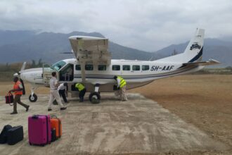 An Auric Air Services Cessna 208B Grand Caravan aircraft being inspected by its crew.