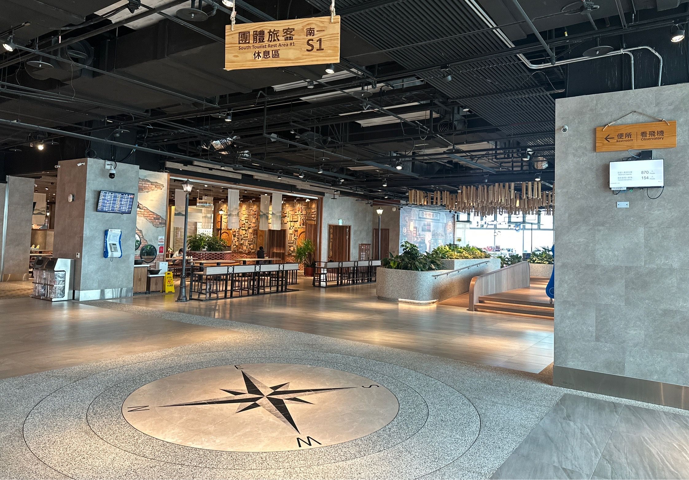 Taoyuan International Airport's lobby, compass design on the floor, seating area in the background.