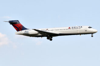 Delta Airline's Boeing 717 in flight against blue skies