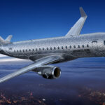 An E175 in flight, with the words "Business Hero" etched on the side of the aircraft.
