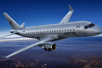 An E175 in flight, with the words "Business Hero" etched on the side of the aircraft.
