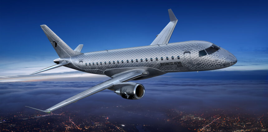 An E175 in flight, with the words "Business Hero" etched on the side of the aircraft.