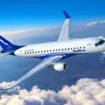 Embraer E175 SkyWest aircraft flying in the blue sky, with clouds.